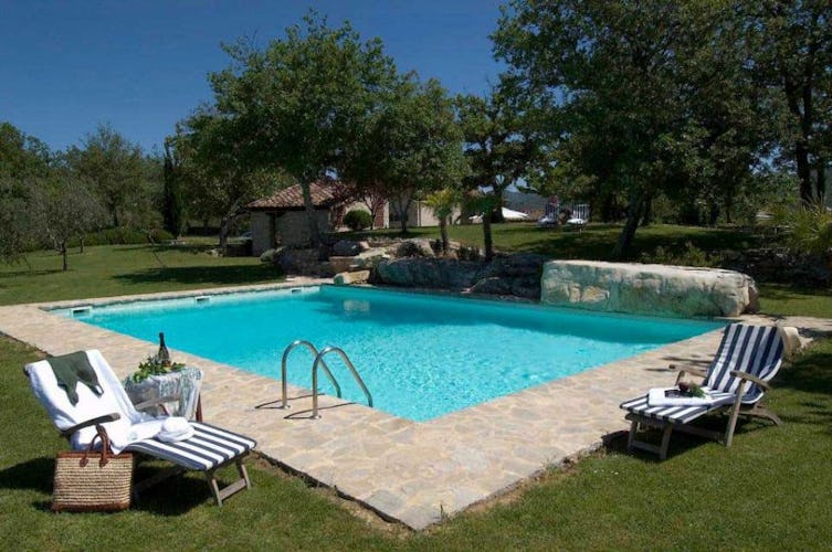 Private holiday swimming pool with lounge chairs and tables