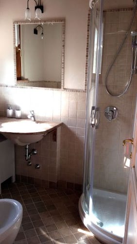 Modern bathroom with shower, bidet, sink and WC