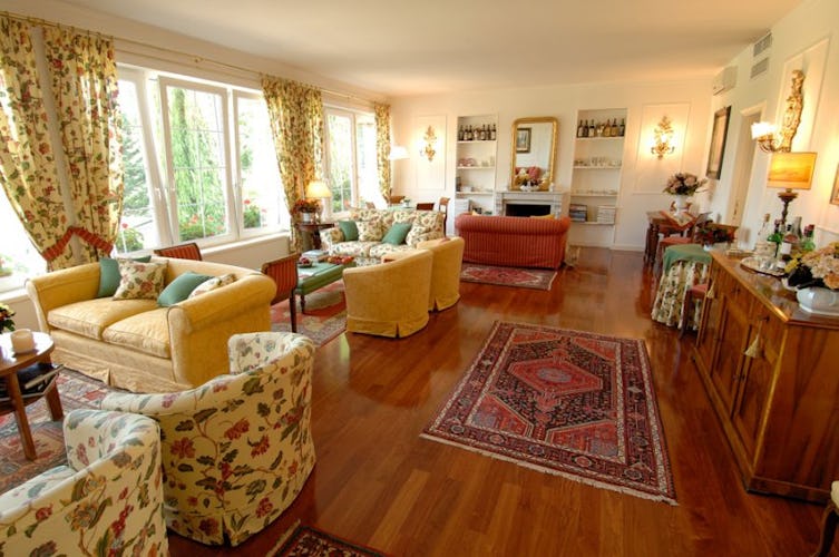 Il salotto accogliente, con pavimenti in parquet ed ampie finestre