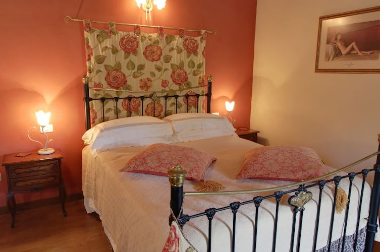 Warm wood floors, and wrought iron bedstands decorate the bedrooms