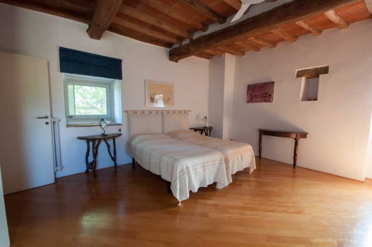 Comfortable wooden floors accent the luminous bedrooms at Montrogoli