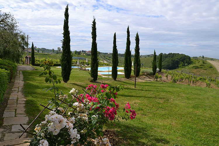 Un ampio giardino con fiori, alberi e piante circonda gli appartamenti