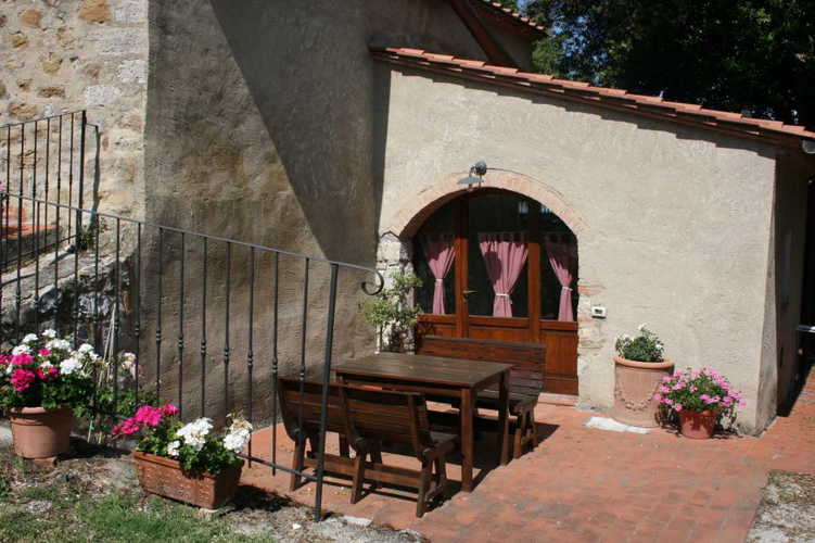 Il patio degli appartamenti ha tavoli e sedie per mangiare all'aperto