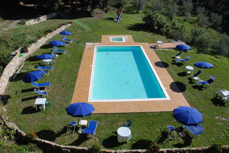La piscina con l'angolo dedicato ai bambini, sdraio ed ombrelloni