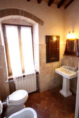 Bagno con terracotta e soffitti a trave