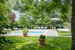 La piscina con il solarium dotato di ombrelloni, sedie e lettini