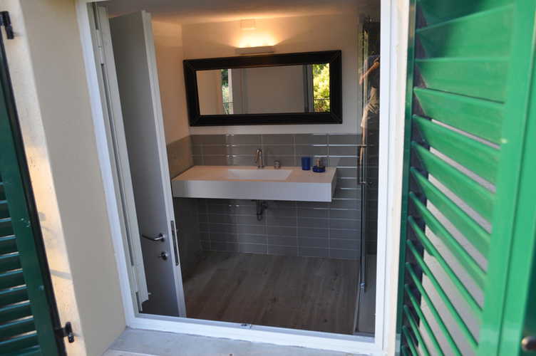 Il bagno, anch'esso arredato in stile moderno con una grande finestra