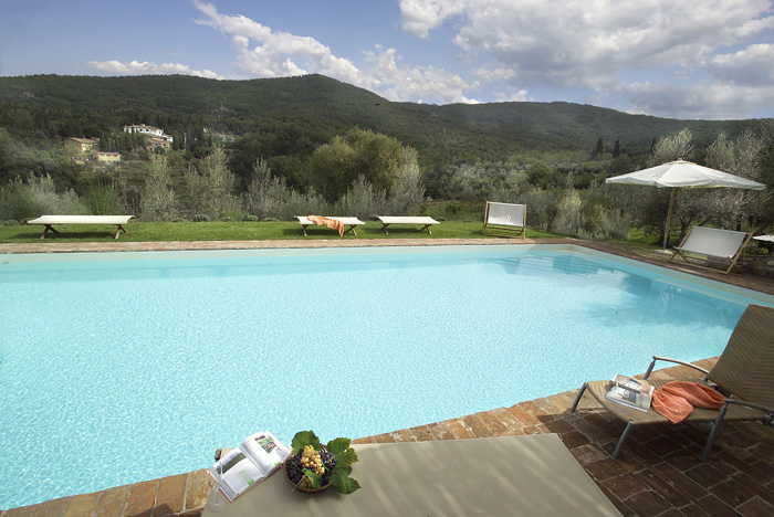 La piscina immersa nel verde rigoglioso del giardino, tra gli oliveti
