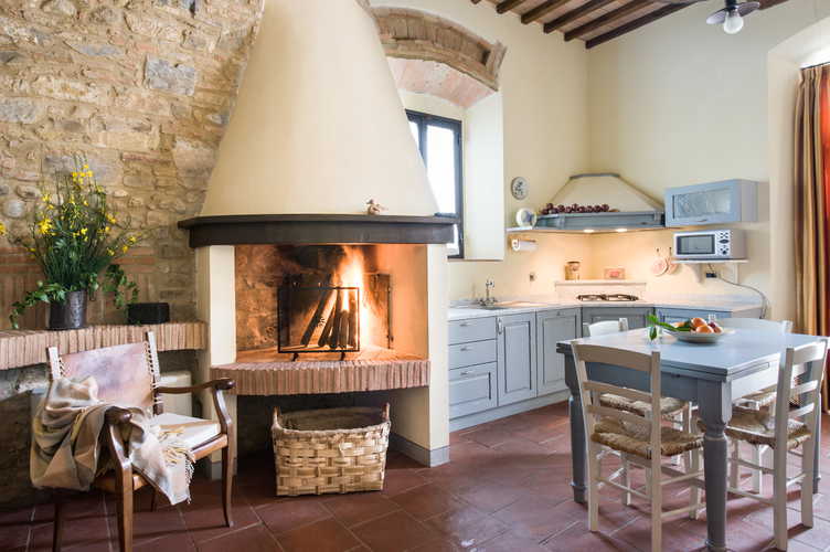 Il bellissimo caminetto in tipico stile toscano, con alle spalle una parete in pietra ed i pavimenti in terracotta