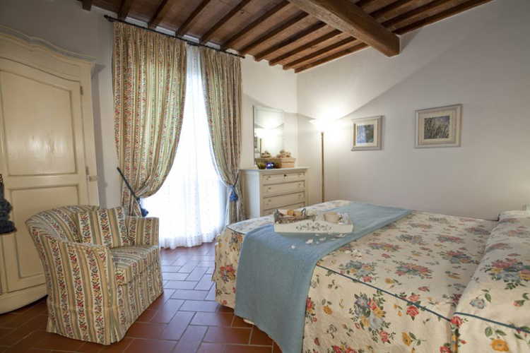 Soffitti con travi a vista e pavimenti in terracotta nelle camere